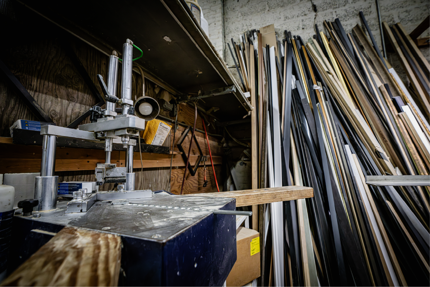 Workshop corner with framing machine and stacked molding strips